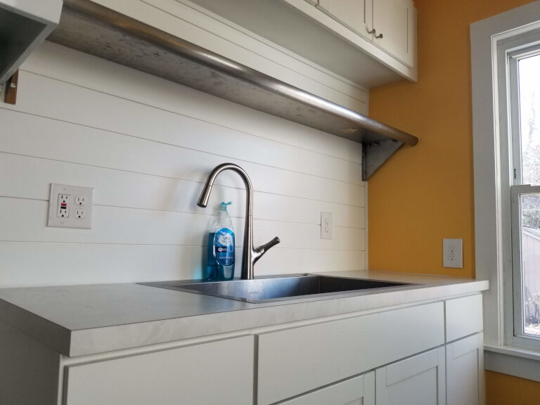 iSpec kitchen detail — stainless sink, shiplap backsplash, code GFCI electrical